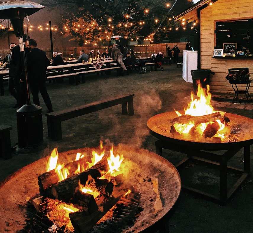 two round firepits burning at a barbeque party 