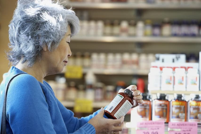 an old woman reading amino acid's label